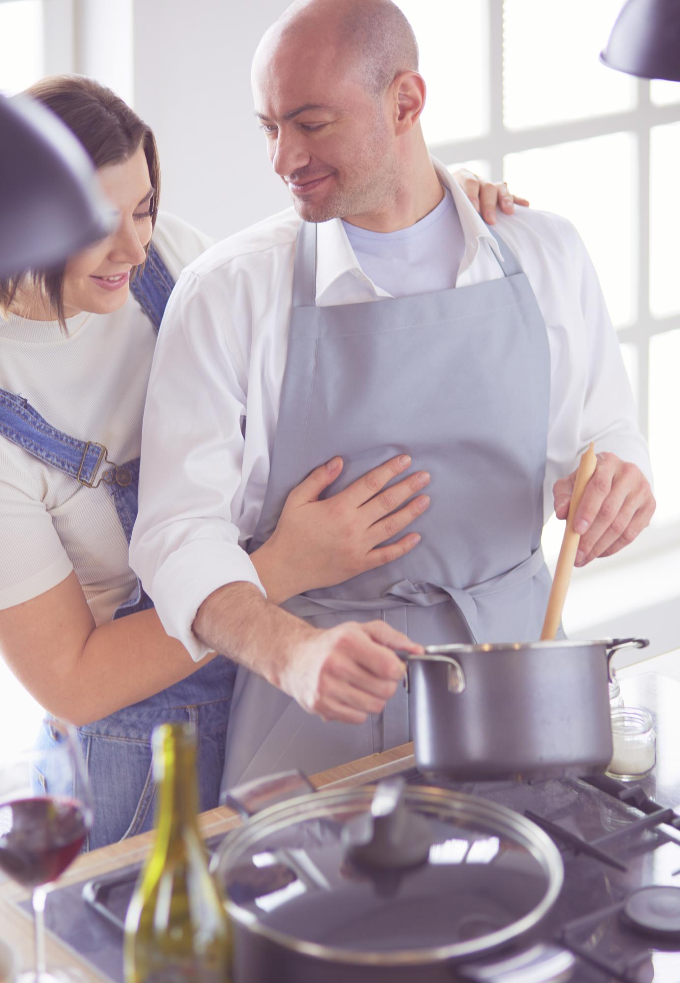 Chef guiding a student on stove technique
